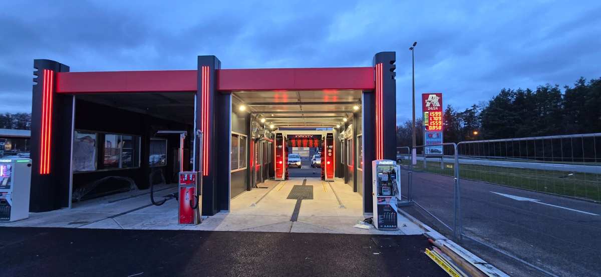 Entrée portiques Exepxion éclairés le soir avec station Auchan